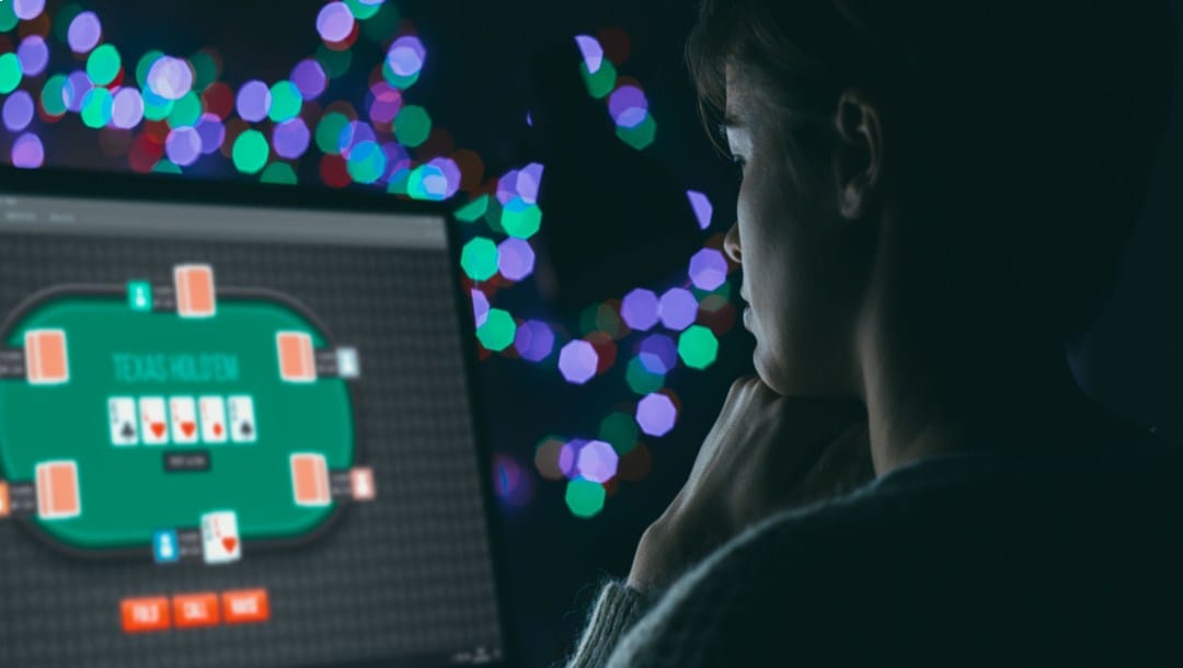 A woman playing Texas Hold’em on a PC.