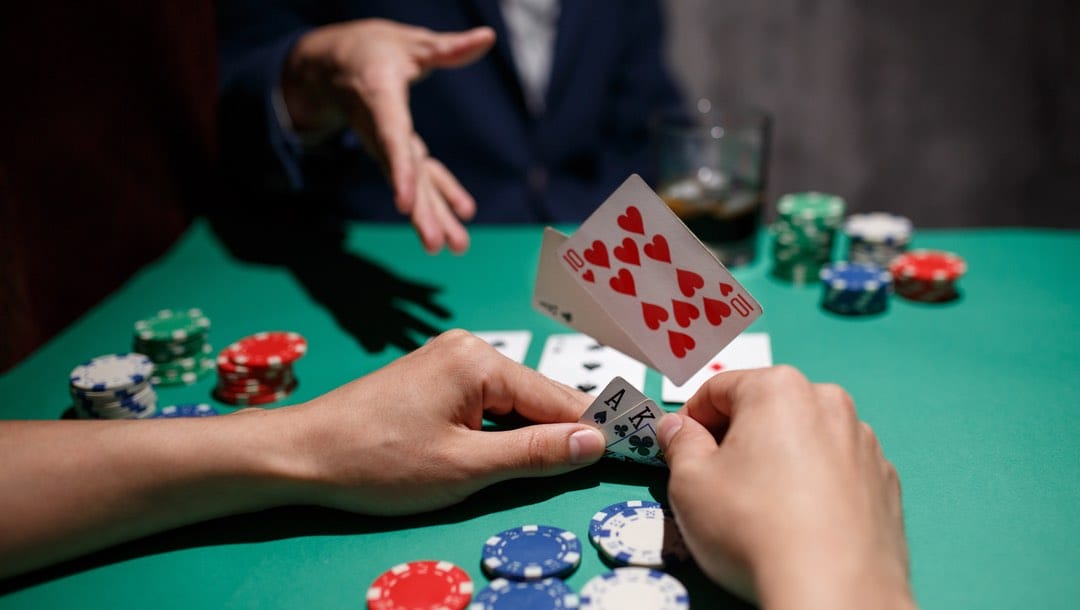 A poker player throws their cards onto the table.