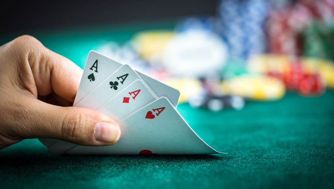A player reveals a hand of four ace cards.