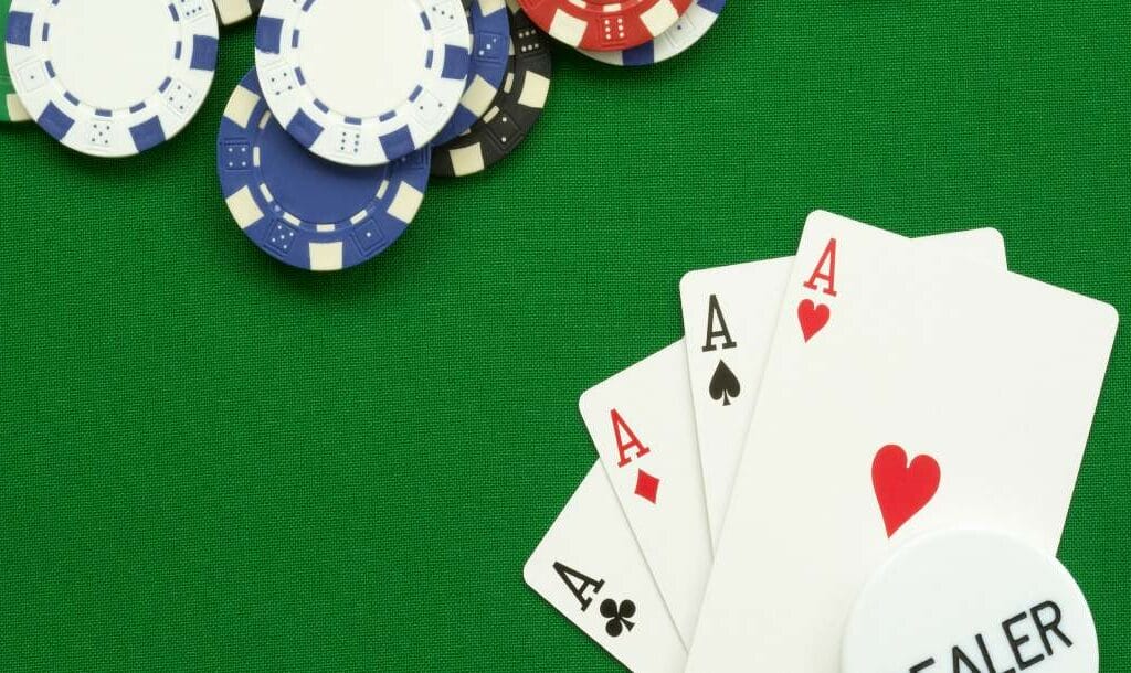 A green poker table with playing cards and poker chips.