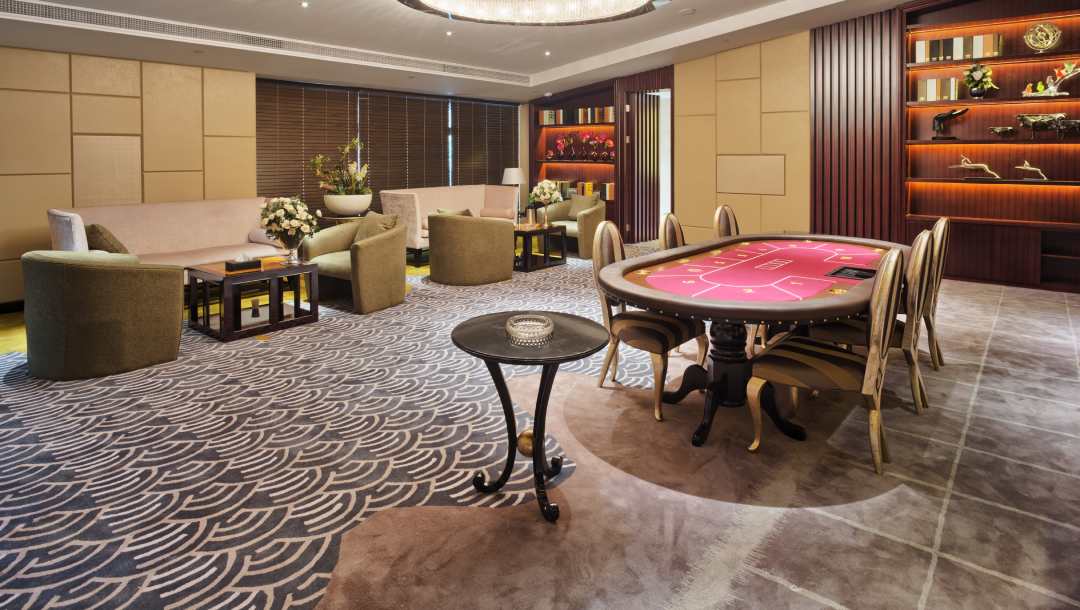 A lounge with furniture and a red felt poker table.
