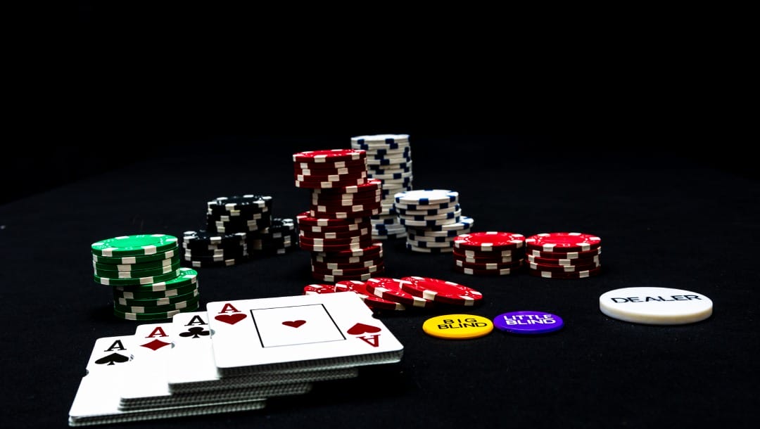 Playing cards and casino chips on a black table.