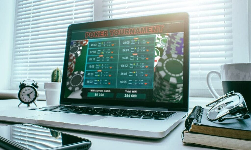 Laptop screen on a desk displaying a live poker tournament online.
