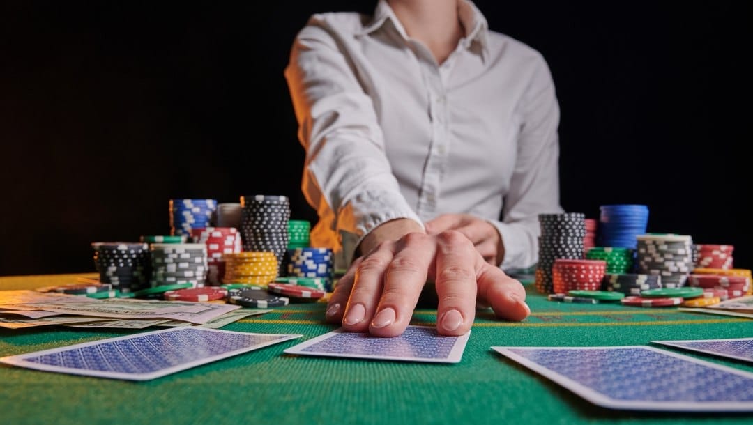 A poker dealer dealing out players’ cards.