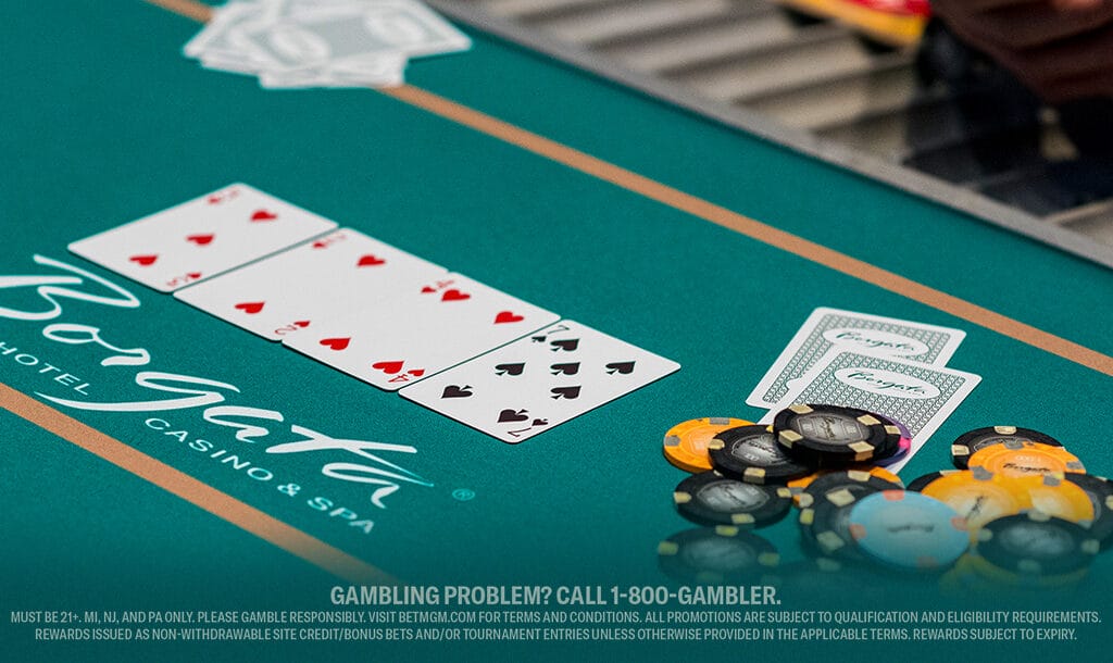 Poker table at Borgata Casino with a winning hand of four aces and various colorful poker chips.
