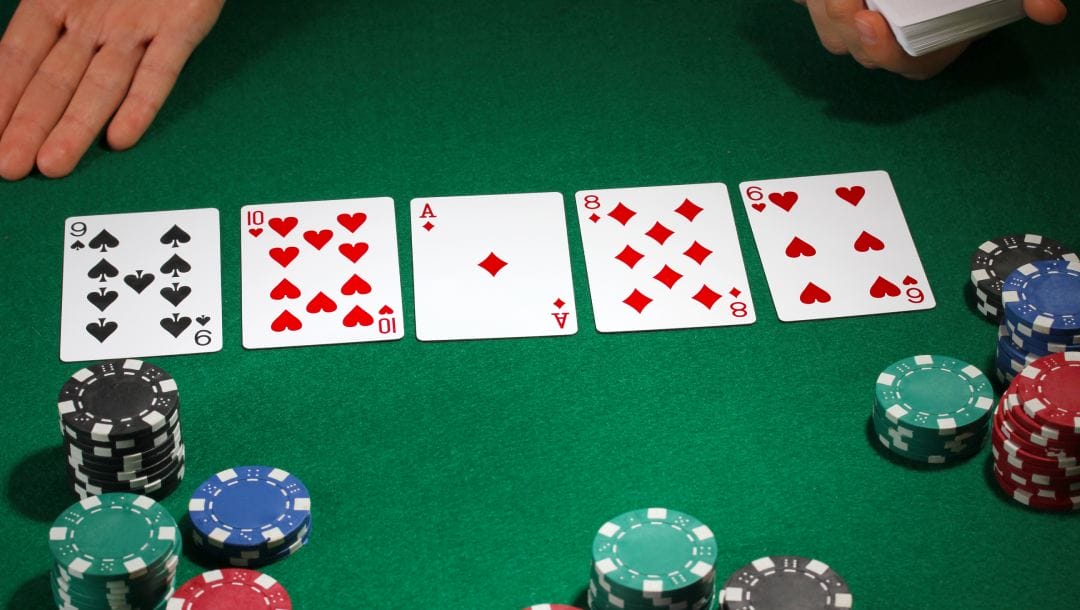 Poker cards and casino chips displayed on a green felt table.