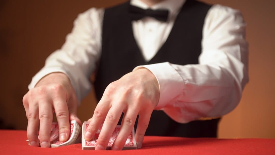 A croupier shuffling cards at a poker table