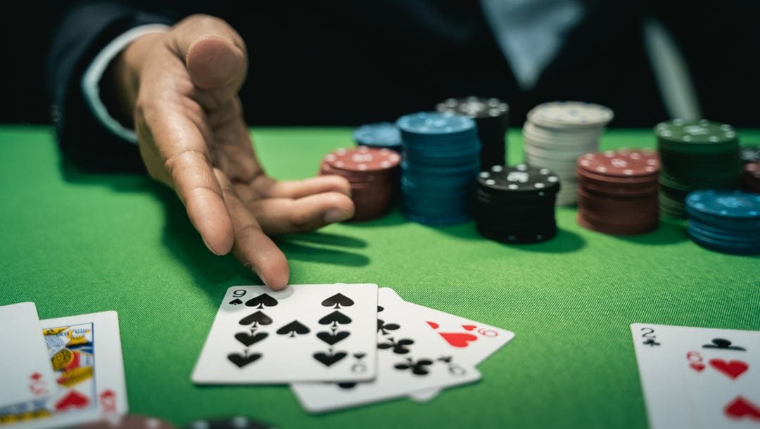 A poker player lays his cards down on the table.