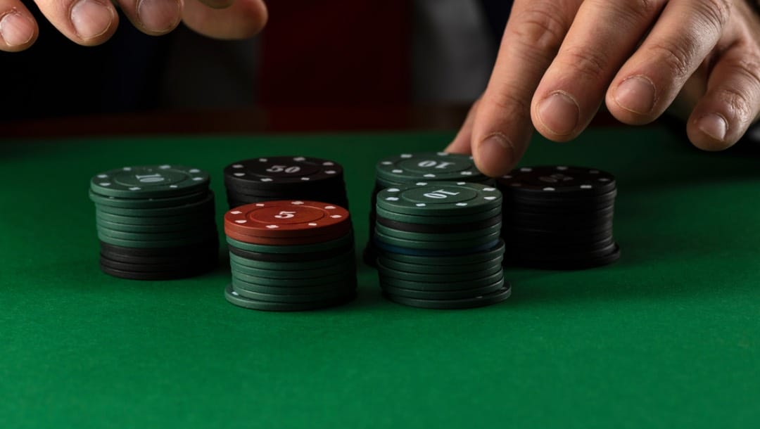 A player picks up a poker chip from the stack.