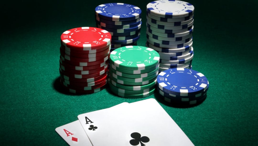 Two ace cards and casino chips on a green felt table.