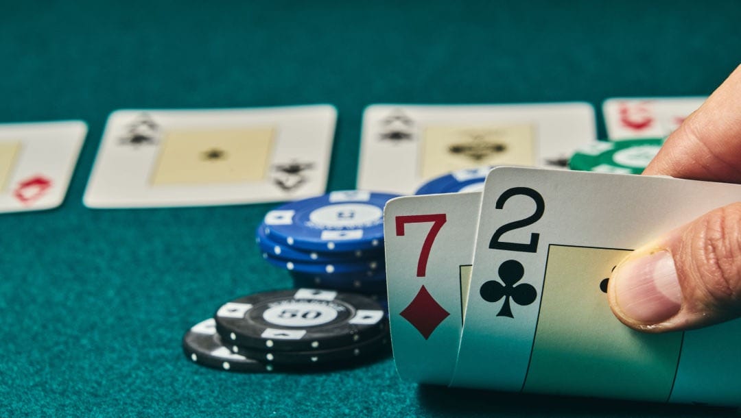Two face-down playing cards revealed on a green felt poker table, surrounded by casino chips.