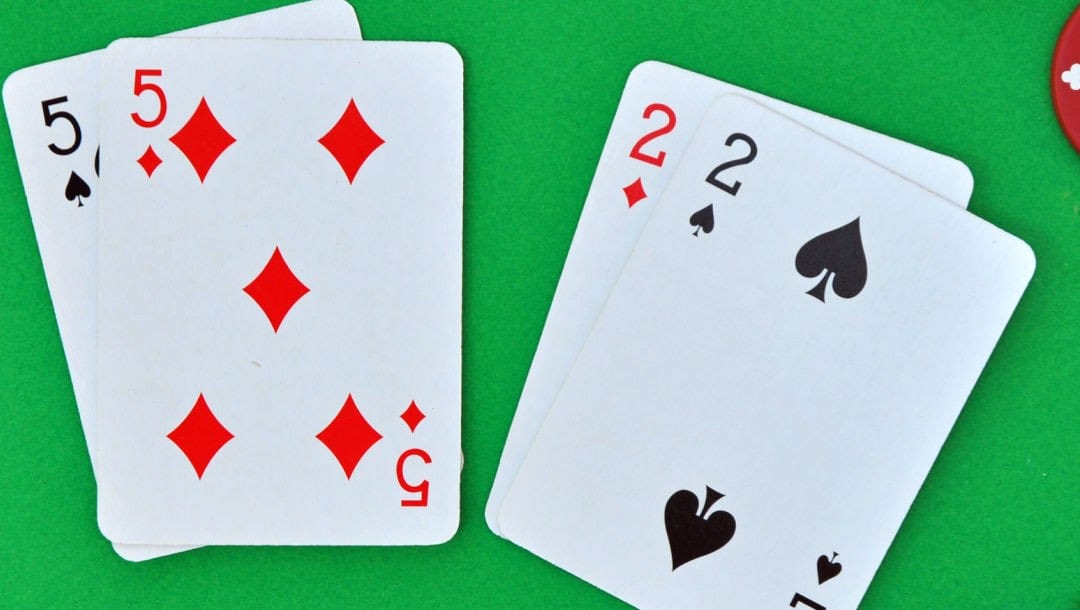 Two sets of poker cards on a green felt table.