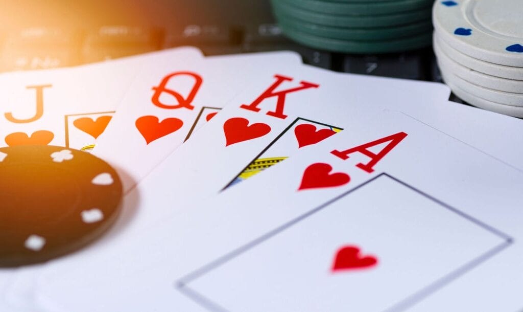 Poker cards featuring a royal flush, surrounded by casino chips.