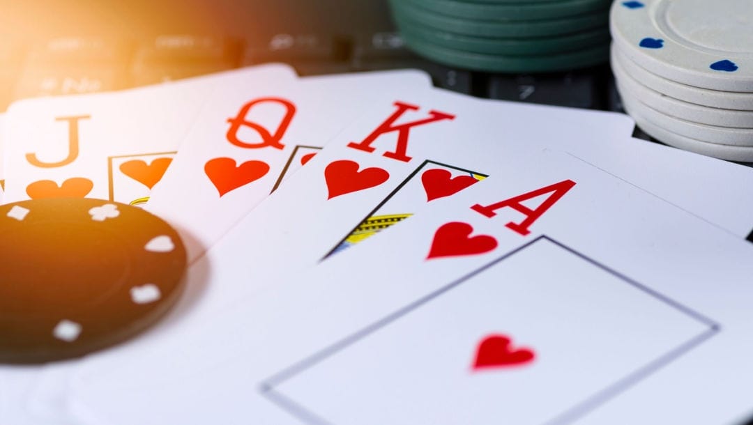 Poker cards featuring a royal flush, surrounded by casino chips.