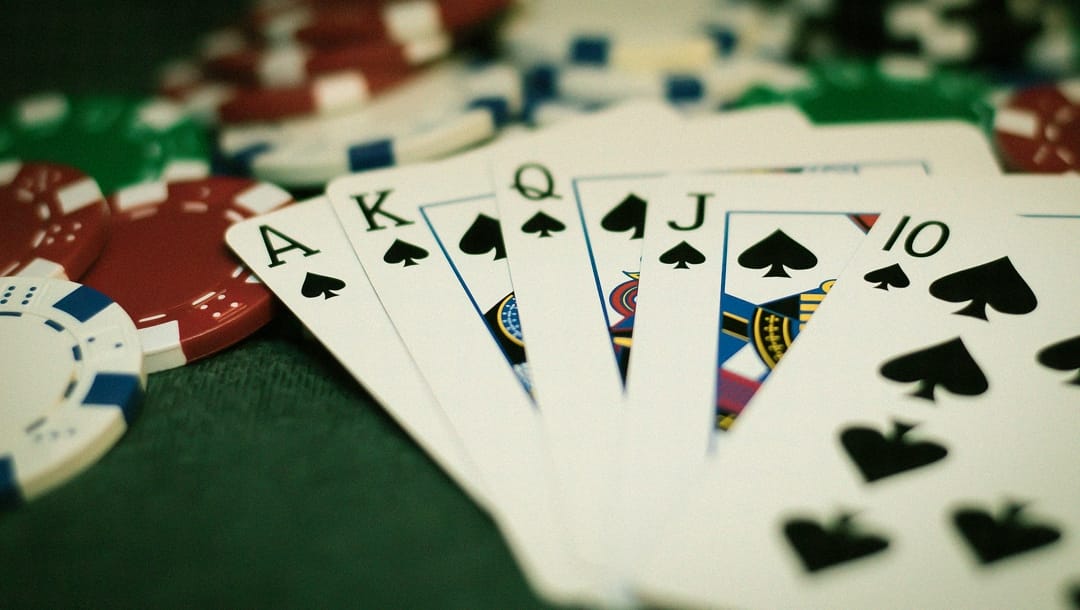 A royal flush sitting on top of scattered poker chips.