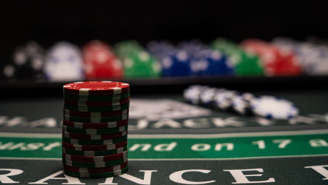 Poker chips on a black and green poker table.