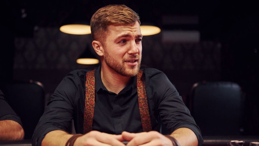 A man with a worried expression sitting at a casino table.
