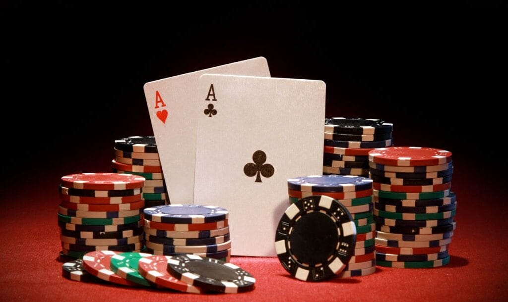Poker chips and cards on a red felt table.