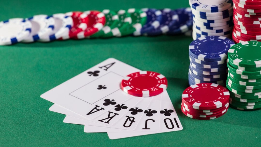 A royal flush with poker chips on the table.