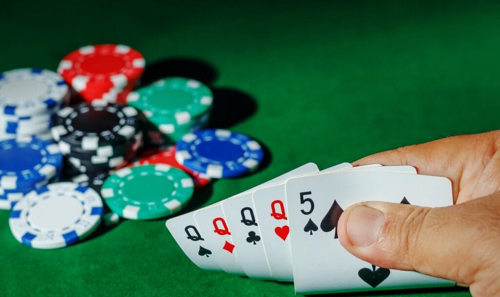 Poker chips and cards on a green felt table.