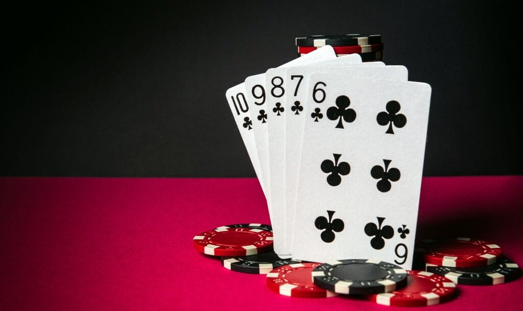 Poker cards and casino chips on a red felt table.