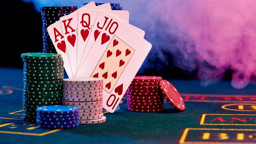 Casino chips and playing cards on a poker table.