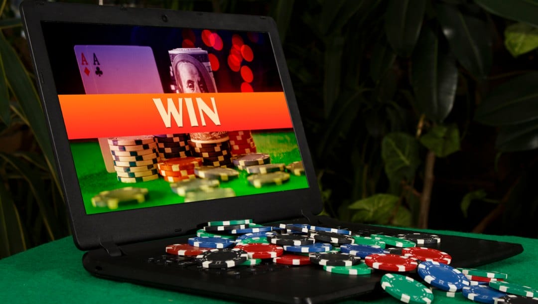Casino chips on a laptop with online poker shown on the screen.