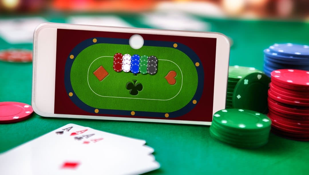 Online poker shown on a smartphone with casino chips and playing cards on a table.