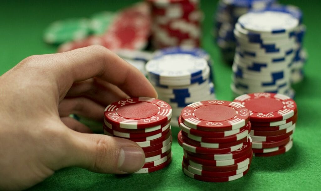 A gambler holding a stack of chips and deciding whether or not to bet.
