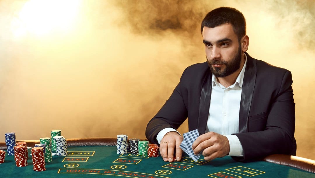 A bearded poker player thinking about his next play.