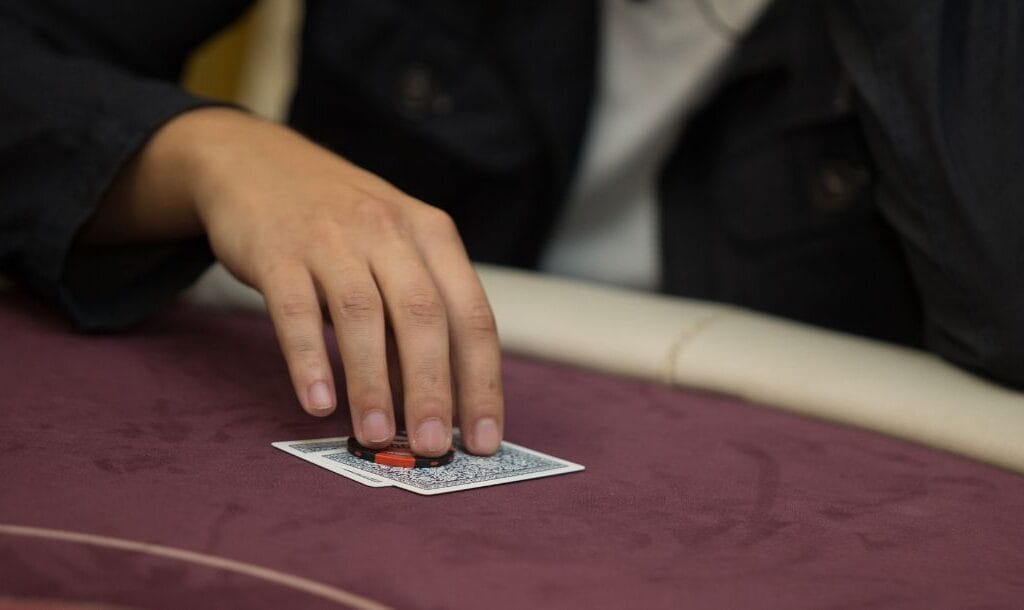 Man picking up his starting hand of two cards