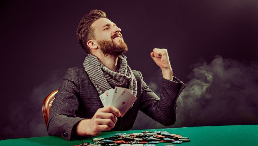 Man celebrates his poker win holding four aces