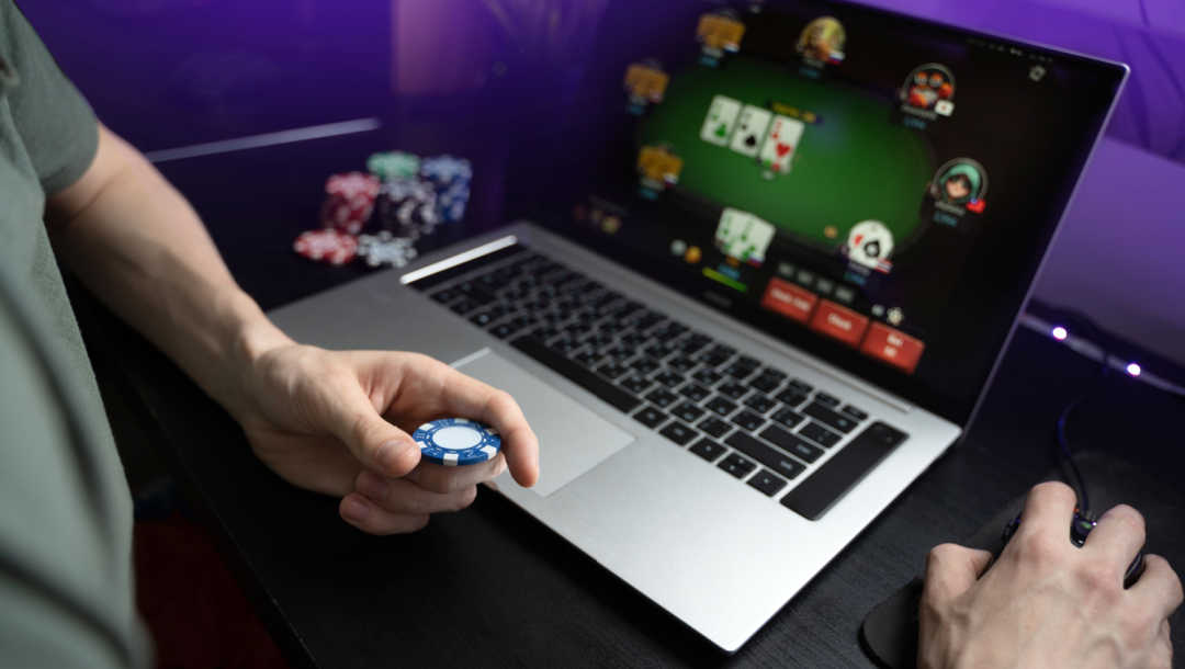 A man holding a chip playing a poker game online