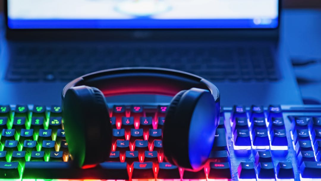 A pro gaming illuminating desk, headset and keyboard.