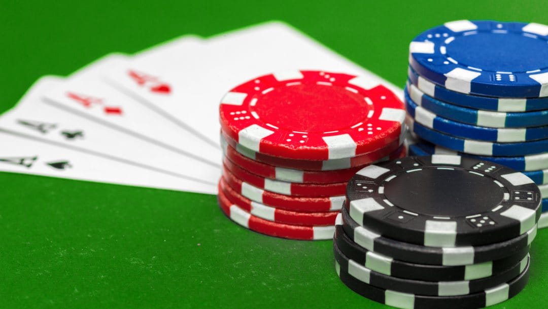 Chips and four aces on a green felt table.