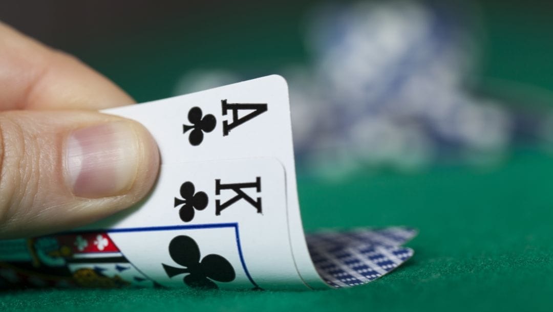 Big Slick poker hand, an ace and king of clubs, on a green felt poker table