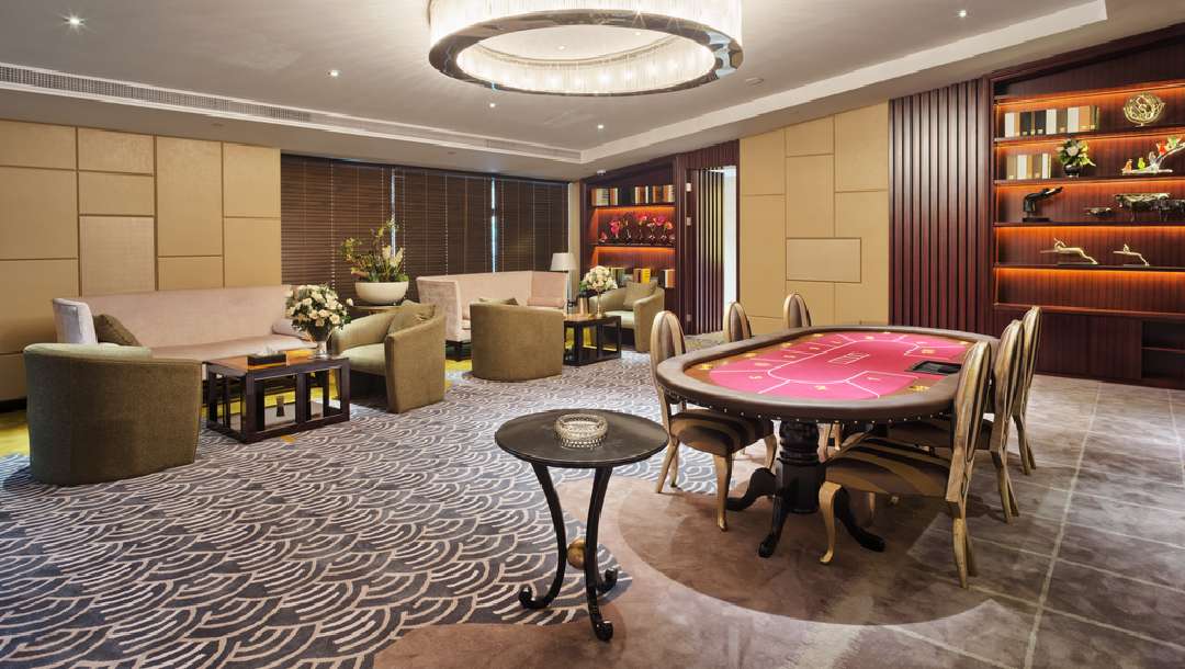 A poker table next to a seating area in a luxury apartment