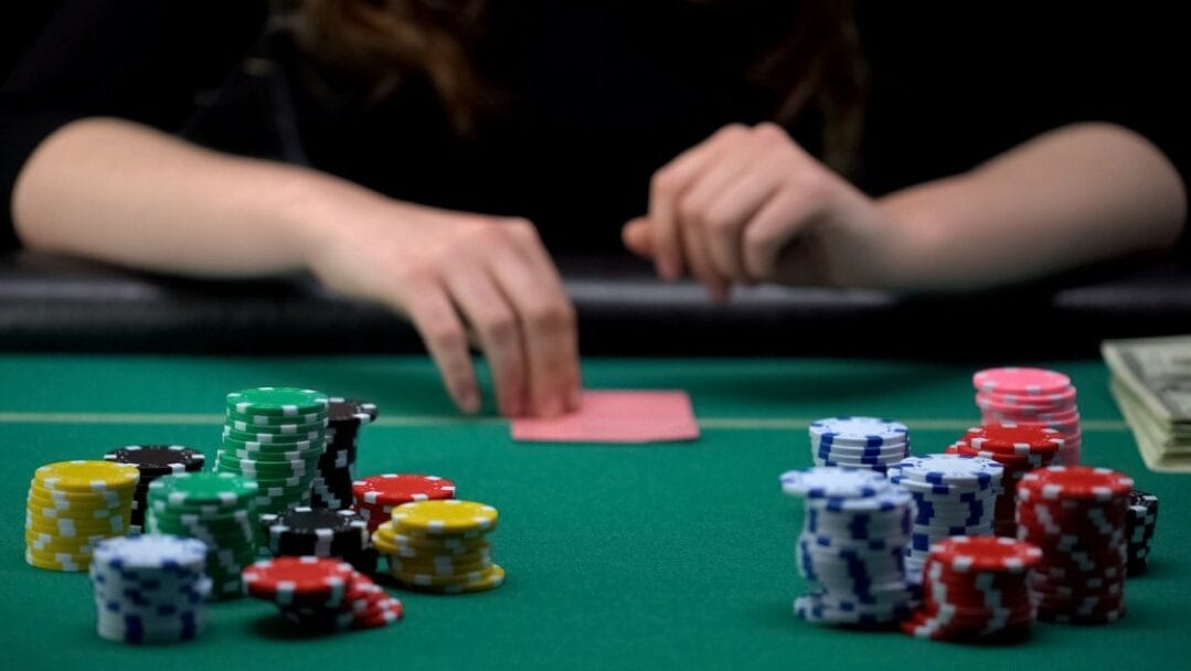 A poker player preparing to turn their hand over.