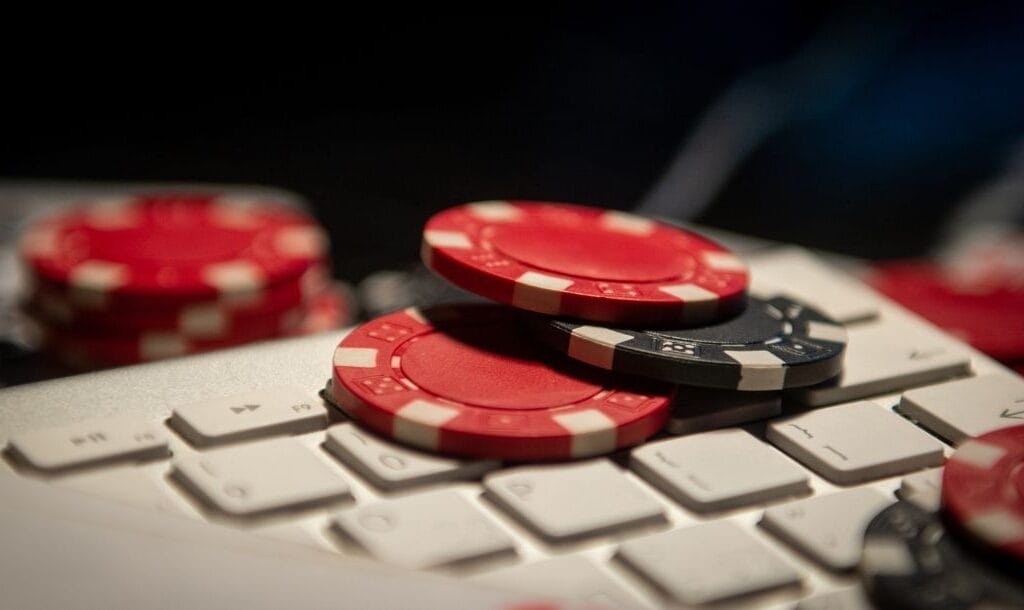 red and black poker chips on a white computer keyboard