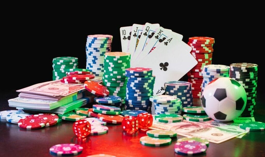 Stacks of casino chips, dollars, playing cards and dice.