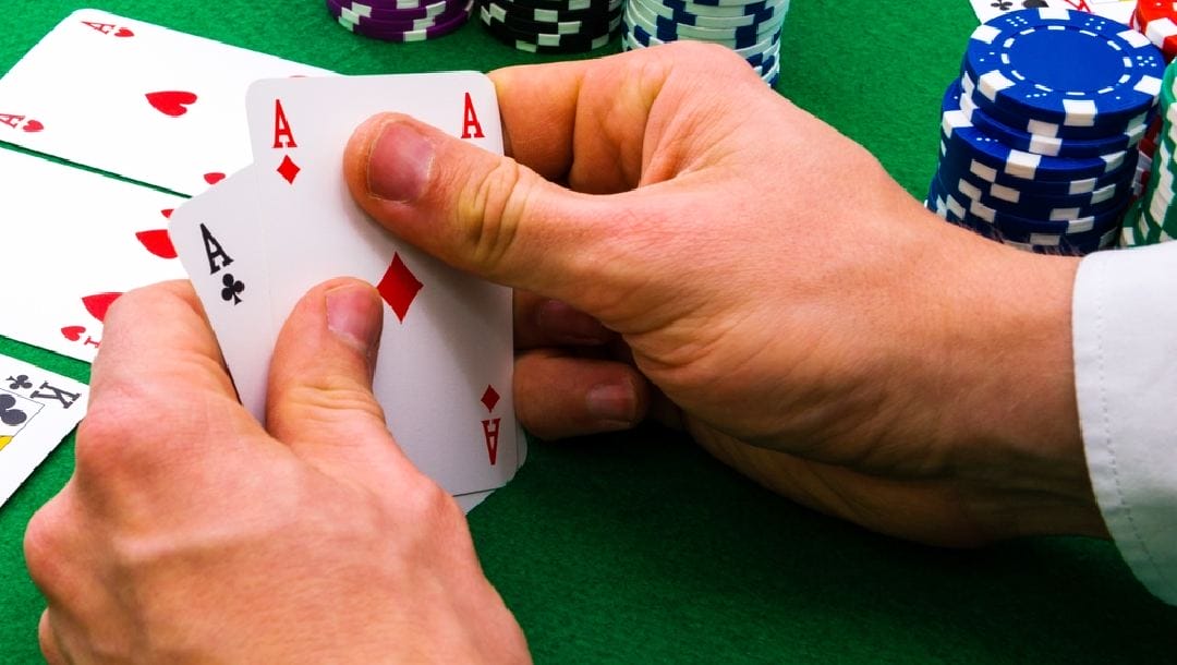 A player’s hands holding an ace-pair.