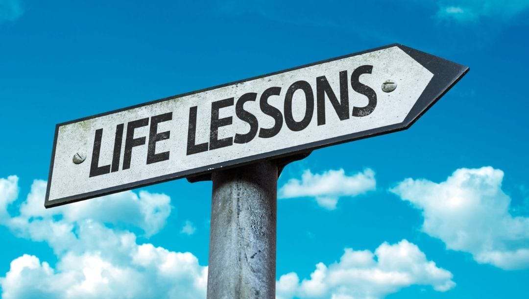 A closeup of a road sign with the words “life lessons” on it with a bright blue sky in the background.