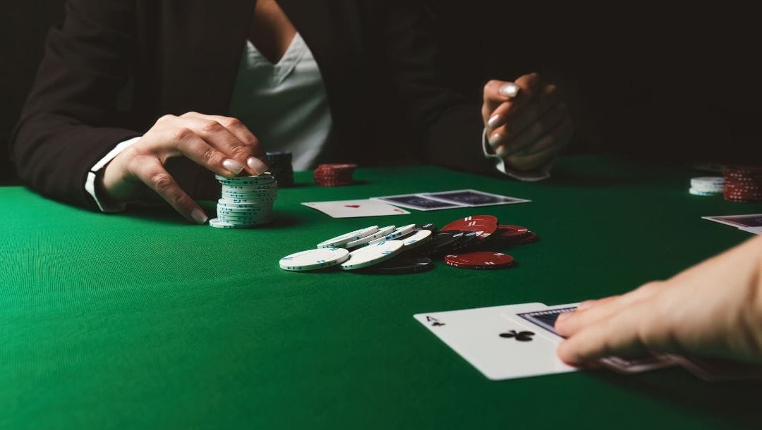 Two men engaged in a poker game at a table, surrounded by cards and poker chips.