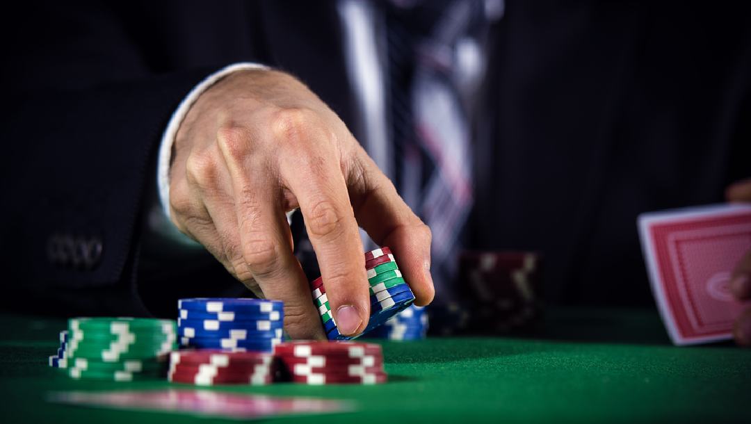 A man picking up chips on the poker table