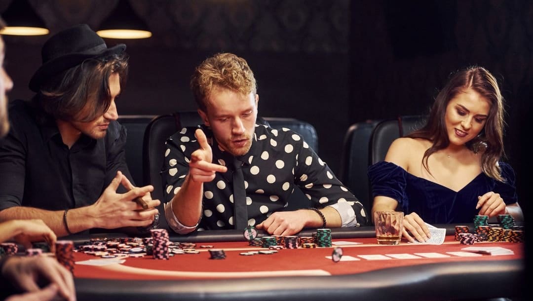 People seated around a poker table, engaged in a game of poker.