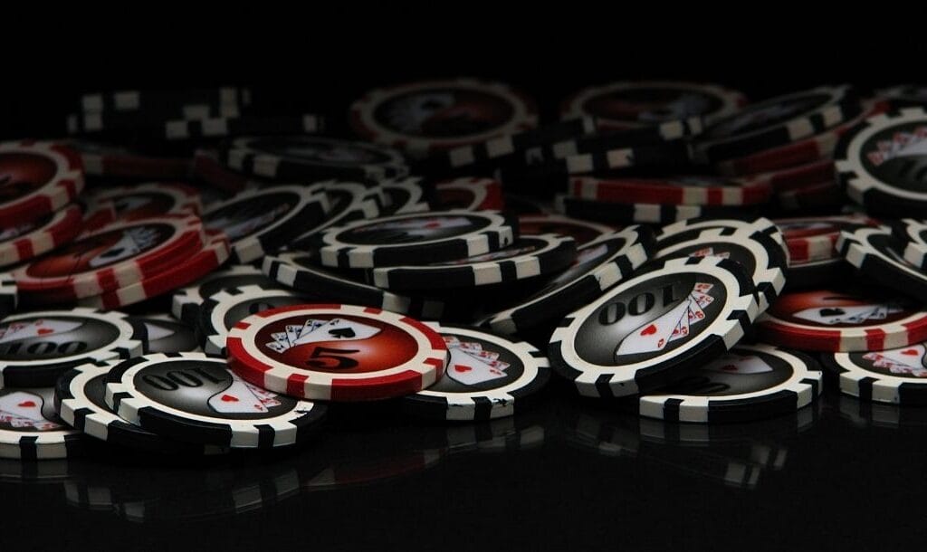 red and black poker chips on a black surface