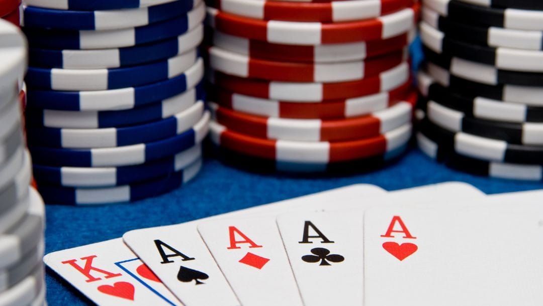 playing cards and poker chips on a blue felt poker table