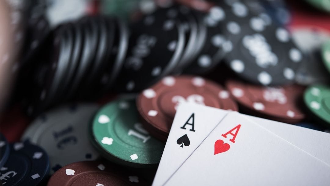 a pocket pair of ace playing cards on top of a pile of poker chips