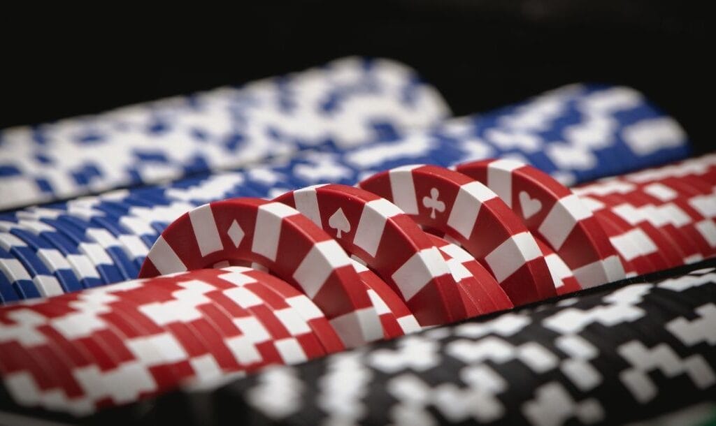 close up of poker chips stacked together in a set with a couple red ones sticking out the top