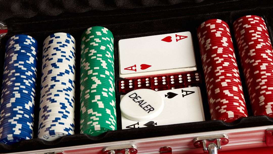 a complete poker chip set comprising of multicolored poker chips, playing cards, red six-sided dice and a dealer token in an aluminum case